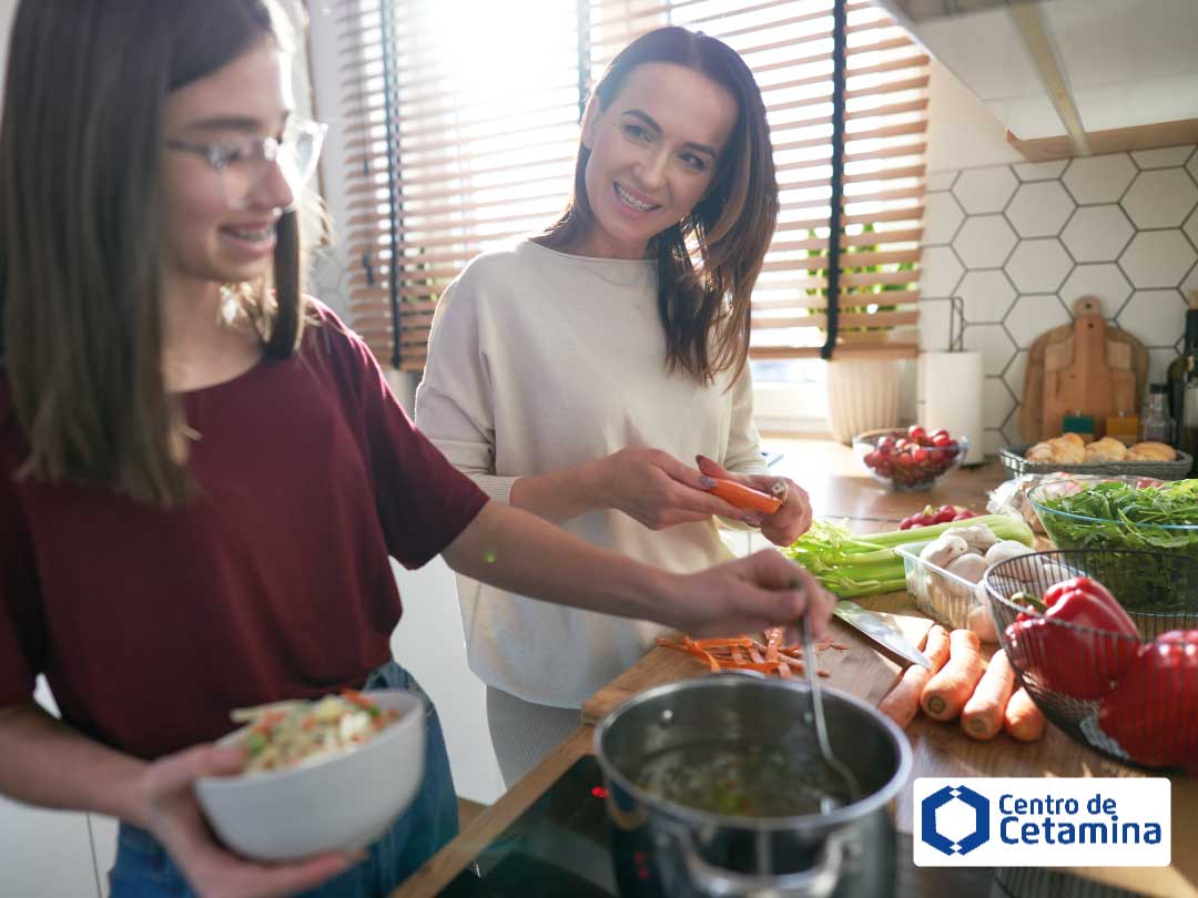 Mãe e filha cozinhando felizes, representando a retomada da rotina e vínculos afetivos após o tratamento para depressão.